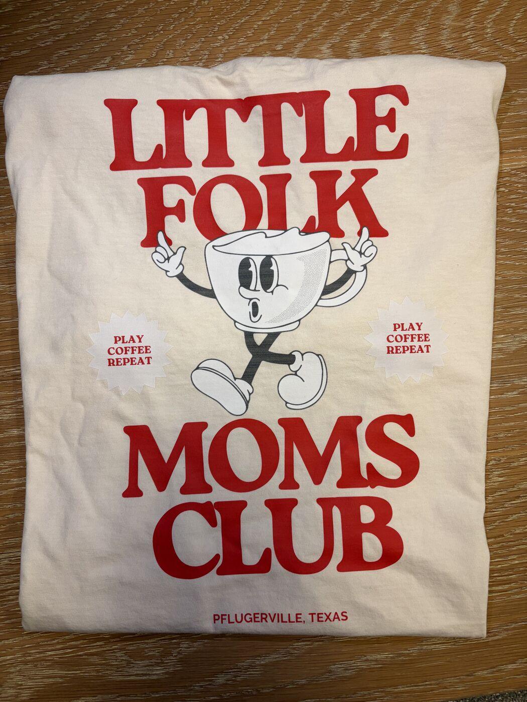Cream t-shirt with a red Little Folk Moms Club print and a dancing coffee cup character